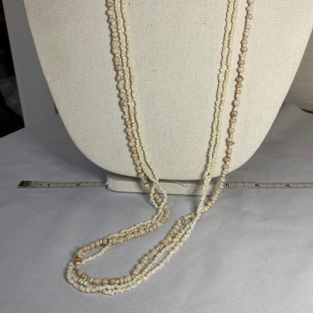 Three very long beige bead necklaces